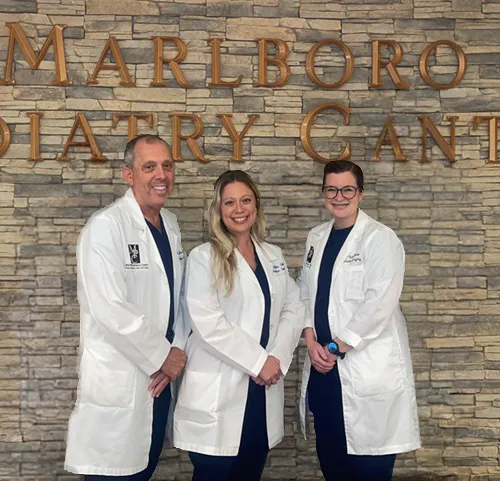 Dr. Marc Cohen, Dr. Allie Cohen and Dr. Kate Florio in front of the Marlboro Podiatry Center sign